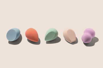 Set of colourful pastel blue, orange, biege, green and purple sponges for makeup on beige background with dark shadows. Beauty blender with different shape. 