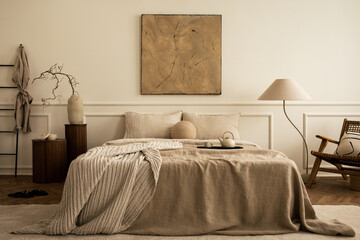 Cozy bedroom interior with mock up poster frame, big bed, beige bedding, plaid, lamp, wooden stands, black ladder, beige rug, wall with stucco and personal accessories. Home decor. Template.