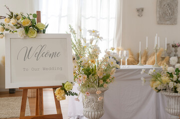 Welcome to wedding sign and reception table decorated with flowers