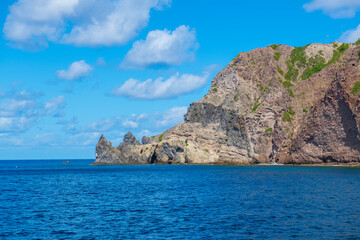 Fototapeta na wymiar Well's Bay Beach with Cape Rhino at the end of the cliff on island of Saba, Caribbean Netherlands. 