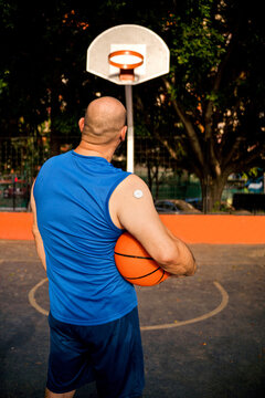 Diabetic man with basketball standing on court