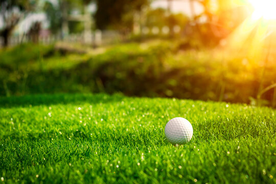 Golf ball close up on tee grass on blurred beautiful landscape of golf background. Concept international sport that rely on precision skills for health relaxation..