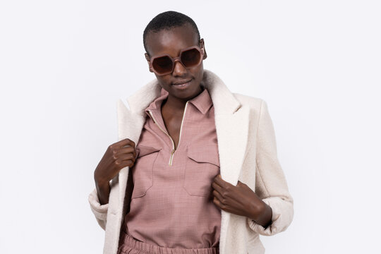 Thoughtful Young Bold African American Female Model In Trendy Outfit And Sunglasses Looking Away On White Background