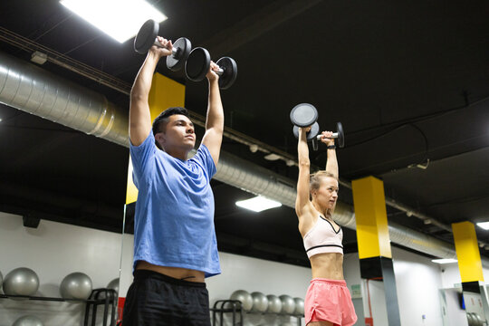 Diverse individuals lifting weights at a gym