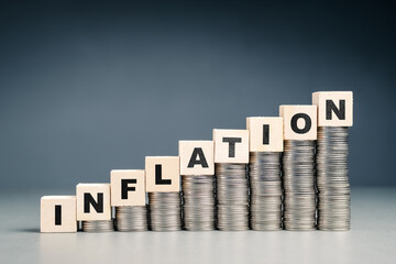 INFLATION word by wood cubes on the stack of money that is higher in each step