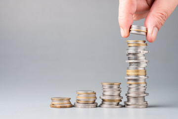 Hand fill coins into the heap at the last step more than it should be, concept for investment, or savings at the long term, and compound interest