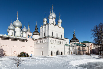 View of the courtyard of the rostov Kremlin with the Gate Church Resurrection of Christ and Assumption cathedral on a sunny winter day. Rostov Veliky, Russia