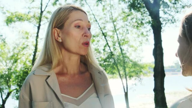 Mother has emotional conversation with daughter in nature. Angry mom lectures daughter for misbehavior during weekends together