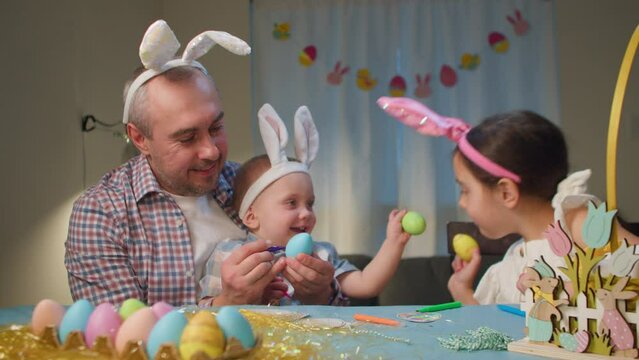 Father with children playing and having fun with Easter eggs. Happy easter