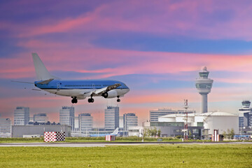 Airplane landing at Schiphol airport in the Netherlands at sunset