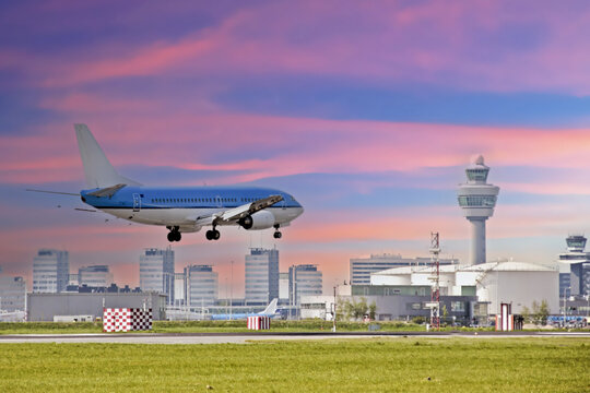 Airplane landing at Schiphol airport in the Netherlands at sunset