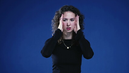 Aprehensive 20s person in distress feeling restless and anxiety standing on blue background