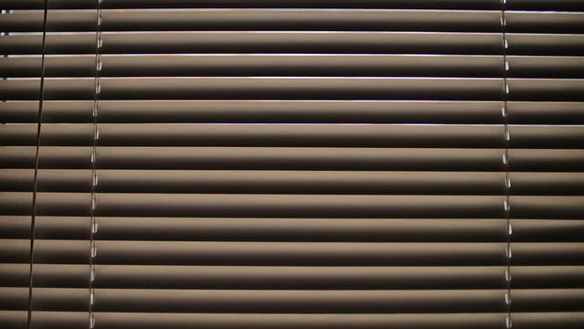 Opening and Closing Blinds in Home. Sun shining through window blinds close.