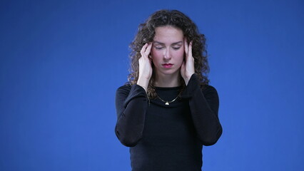 Stressed woman calming herself with hands on temples feeling distress and headache. Person...