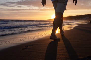 Footprints of a man walking barefoot on a sandy beach. A sunny path