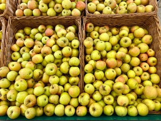Green apples in a basket are on the counter of a store, fruits in a supermarket.