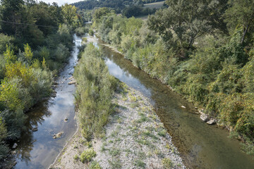 Fiora river green banks and shoal south of Mirafiora bridge, near Pitigliano, Italy