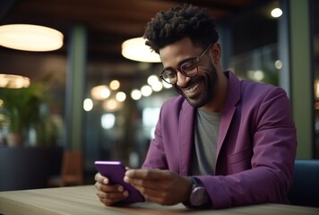 man wearing a purple sweater with glasses is smiling with phone