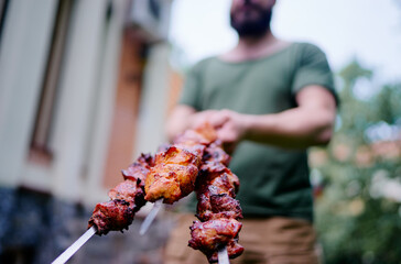 Man holding Barbecue beef pork shashlik. Cooking outdoor