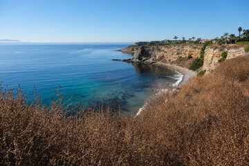 Breathtaking scenic and landscape view of coastline of Rancho Palos Verdes with vegetation and cliffs and beautiful bays overlooking ocean and coast in California on sunny blue sky day