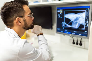 A radiologist looks at an x-ray image in his lab