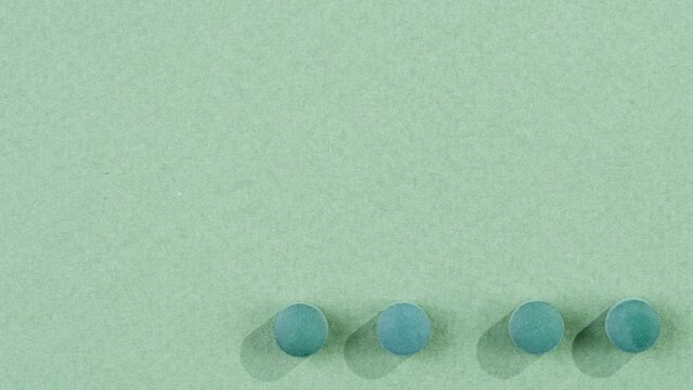 Green mint mentol lollipops, mdma candies, bonbons disappear on purple background. Summer bright texture studio shot for store, supermarket, close up top view. Children favorite sweets made of sugar. 