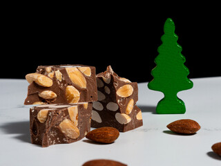 Turrón de chocolate y almendras con fondo navideño