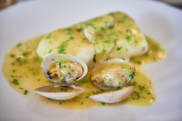 View of the typical basque country dish, Hake with Clams and Kokotxas and Pil-Pil sauce.