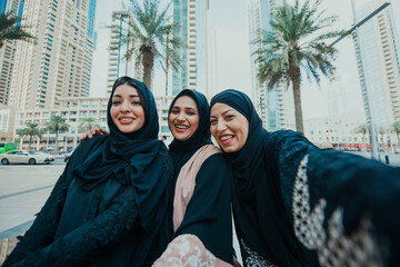 Three women friends going out in Dubai. Girls wearing the united arab emirates traditional abaya