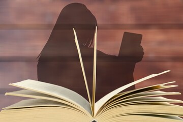 Woman silhouette reading a book. Knowledge day