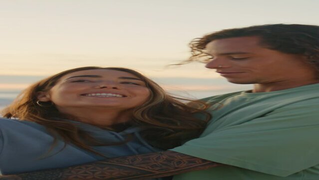 Cheerful teenagers making selfie at sunset vertical closeup. Man kissing woman