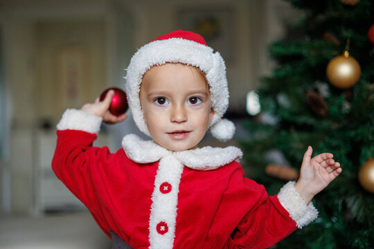 .Niño Vestido De Papa Noel Montando Un árbol De Navidad 