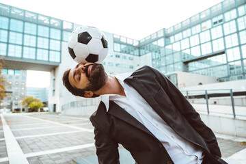Businessman playing with a soccer ball and making freestyle tricks - obrazy, fototapety, plakaty