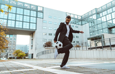 Businessman playing with a soccer ball and making freestyle tricks