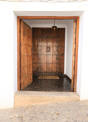 Old wooden door on whitewashed house in Ronda city