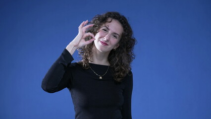 Person Giving Thumbs Up and OK sign with hands to Camera on Blue Background. Woman approving concept
