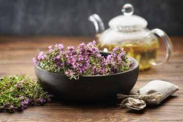 Bowl of thyme healing herbs, sachet bag full of thymus serpyllum medicinal herbs. Glass tea kettle...