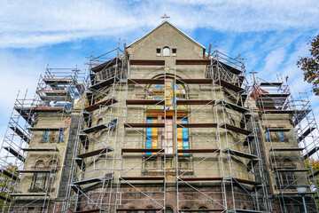 Facade restoration and roof repair of an old Lutheran stone church using complicated scaffolding
