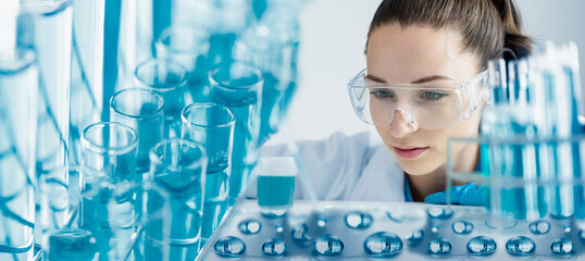 Medical research laboratory concept, Female scientist in goggles using micro pipette for test...