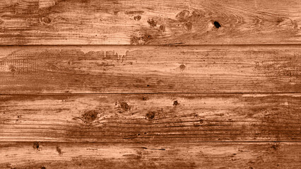 The background of old wooden boards painted in new trendy color of 2024 year Peach Fuzz. Texture top view. Blog backdrop for text signs design. Abstract wallpaper, wooden surface.