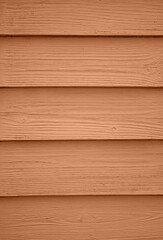 The background of old wooden boards painted in new trendy color of 2024 year Peach Fuzz. Texture...