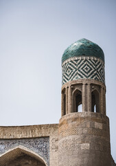 An ancient minaret of a brick mosque faced with ceramic tiles and mosaics in the ancient city of...