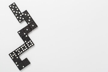 Black domino tiles on white background, top view