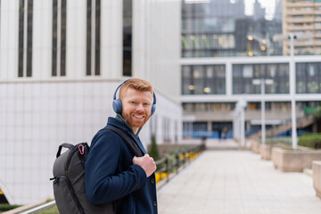 Red-haired man heading to his last day of university, prepared for internships at a successful company in an international trade center