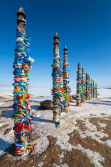 Fototapeta premium Wooden ritual pillars with colorful ribbons on cape Burkhan
