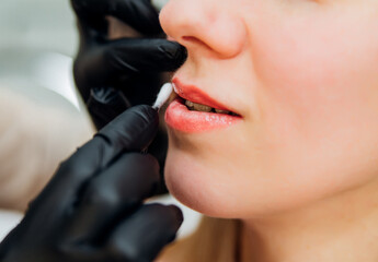 Cosmetic lip moisturizing procedure. A nutrition balm is applied to the lips. Vitamin complex.