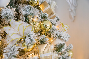 white modern christmas decoration. luxury interior with Christmas tree decorated, golden textile, golden presents,balls .festive tree decorated with garland, baubles, traditional celebration