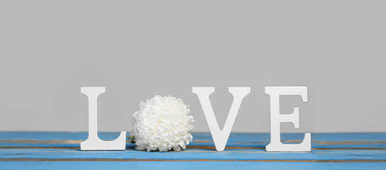 Word LOVE and beautiful flower on grey background. Valentine's day celebration