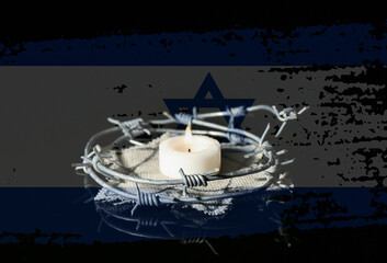Burning candle with barbed wire and Jewish badge on dark background. International Holocaust...