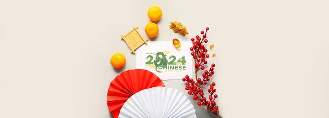 Dragon figure with greeting card, tangerines and paper fans on light background with space for text. Chinese New Year celebration